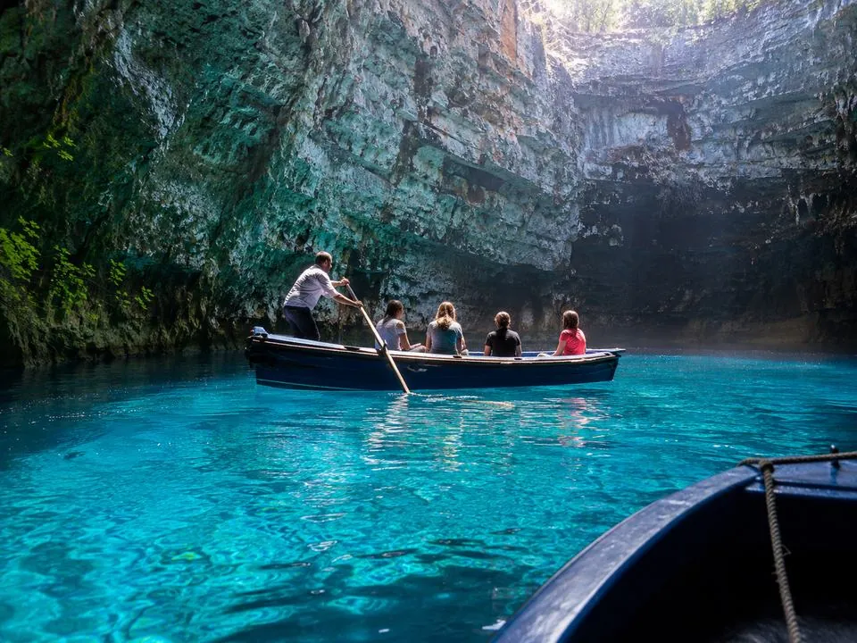 Una barca a remi condivisa con un barcaiolo che attraversa la camera aperta di Melissani Cave