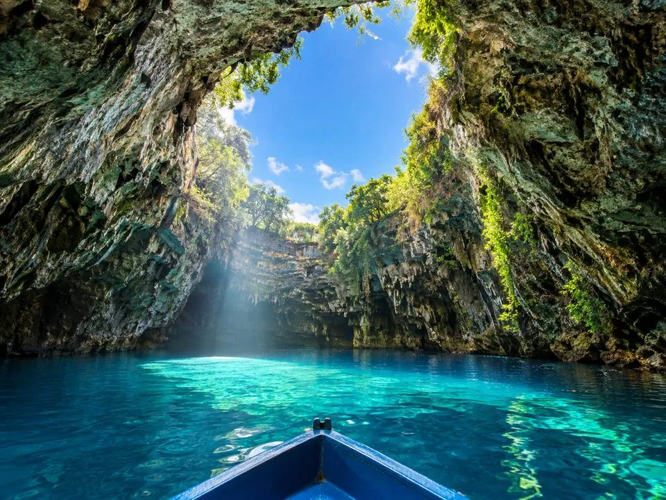 Luce solare attraverso il soffitto crollato sull’acqua turchese del Melissani Lake
