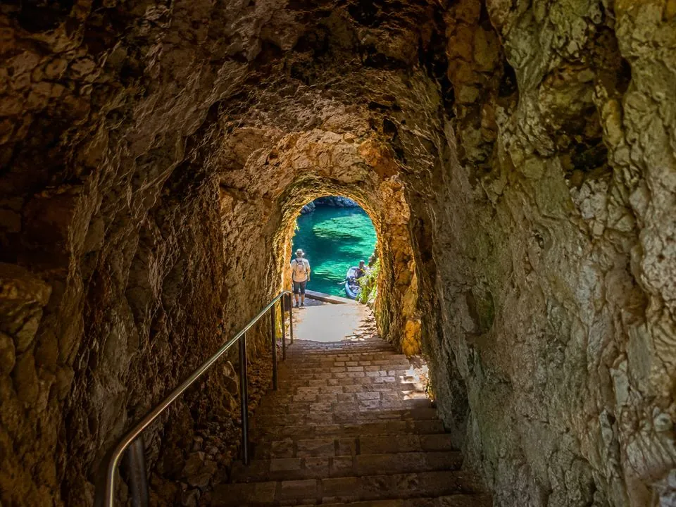 Il tunnel in pietra con gradini che scende al molo di Melissani
